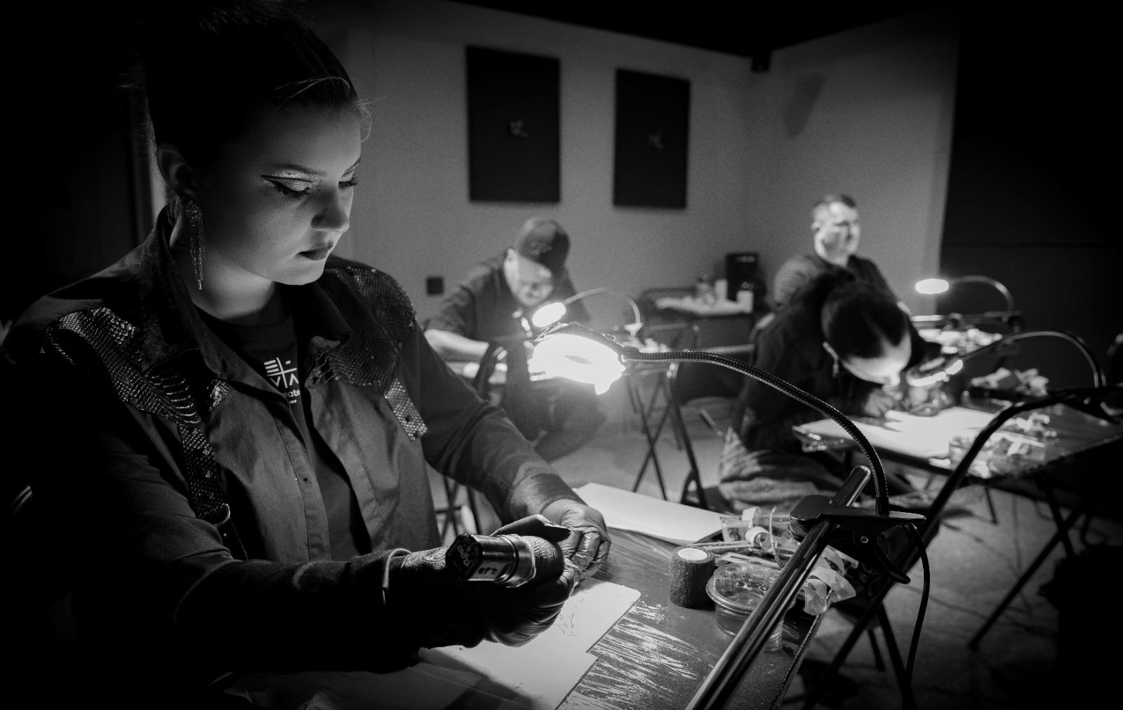 Cursantă în timpul unui exercițiu practic de tatuaj